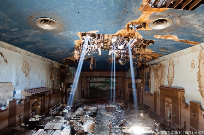 Sunlight pours in through holes in the ceiling, due to years of water damage.